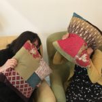 Two people hiding behind cushions
